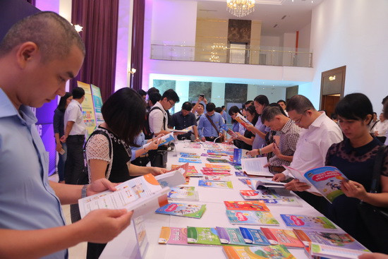 Đại biểu tìm hiểu các bộ SGK lớp 1 được giới thiệu bên lề hội thảo. Ảnh: Việt Hà