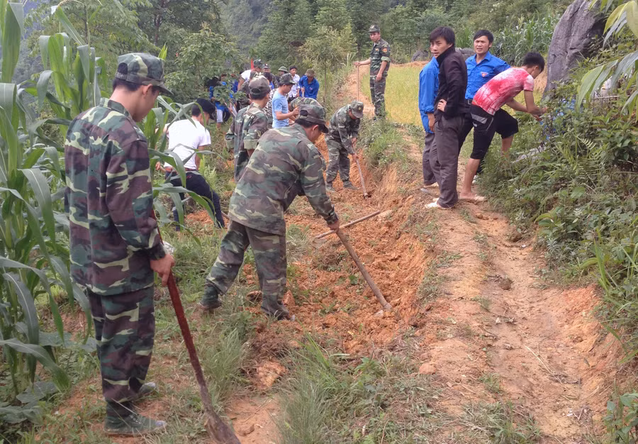 Cán bộ Đồn Biên phòng Xín Mần cùng người dân phát quang đường tuần tra biên giới.
