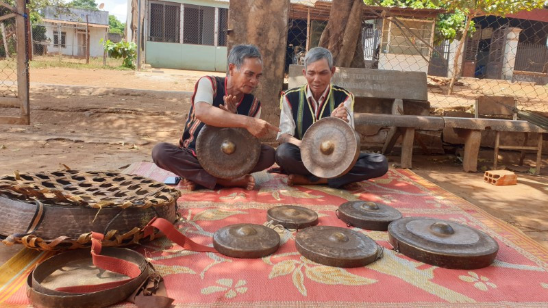 Già Rah Lan Nam (bên phải) “chữa bệnh” cho chiêng mỗi khi bị lạc nhịp.