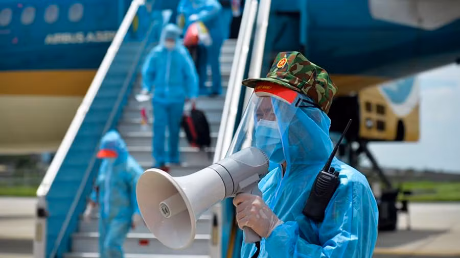 Nhân viên an ninh sân bay Nội Bài hướng dẫn hành khách về các khu cách ly tập trung theo quy định.