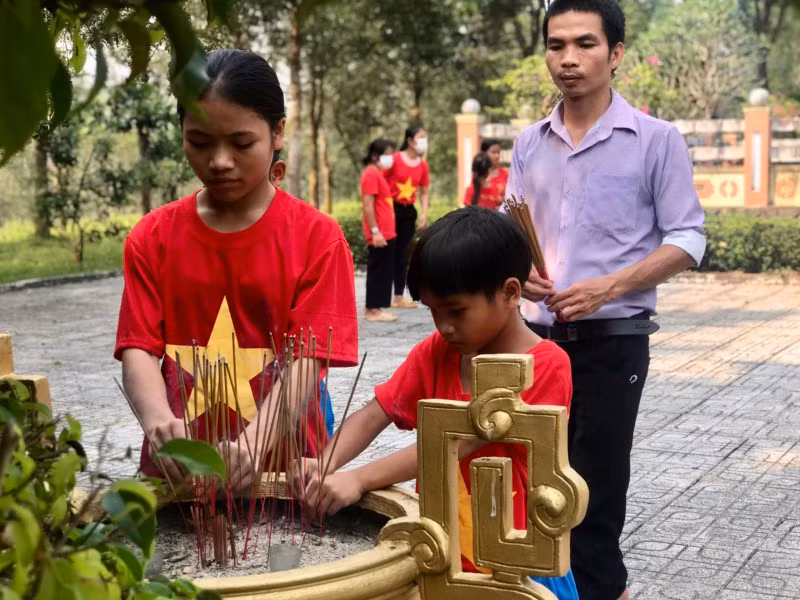 Thầy Vũ Thái Bình - Tổng phụ trách Đội Trường Phổ thông dân tộc Bán trú THCS Nguyễn Bỉnh Khiêm cùng học sinh thắp hương tại Di tích lịch sử Đảng bộ huyện Bắc Trà My.