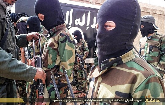 Một tướng lĩnh IS chỉ bảo cách dùng AK-47 để tấn công cho một cậu bé da trắng. Ảnh: Daily Mail Một tướng lĩnh IS chỉ bảo cách dùng AK-47 để tấn công cho một cậu bé da trắng. Ảnh: Daily Mail