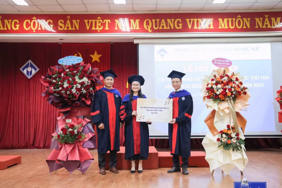 Đại diện tập thể tân cử nhân tặng hoa lưu niệm cho Trường ĐH Ngoại ngữ, ĐH Huế.