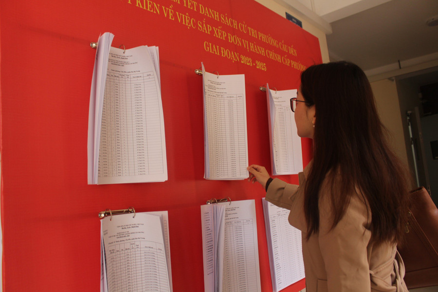 Cư dân phường Cầu Dền (Hà Nội) xem thông báo niêm yết danh sách cử tri, lấy ý kiến việc sắp xếp đơn vị hành chính cấp phường.