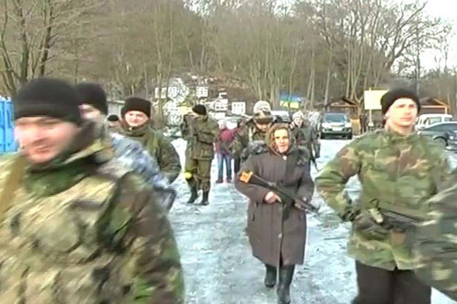 Bà Bilyik cầm súng bên cạnh các đồng đội trẻ hơn mình vài chục tuổi. Ảnh: Youtube. lao-9982-1421919242.jpg