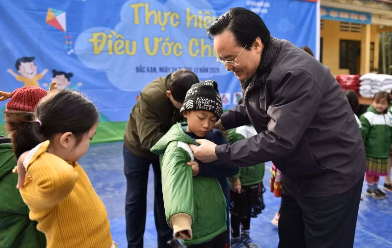 Bộ trưởng Phùng Xuân Nhạ khoác áo ấm cho các em học sinh tại Trường Phổ thông Dân tộc Bán trú Tiểu học &amp; THCS Nhạn Môn (Pác Nặm, Bắc Kạn). Ảnh: Thế Đại