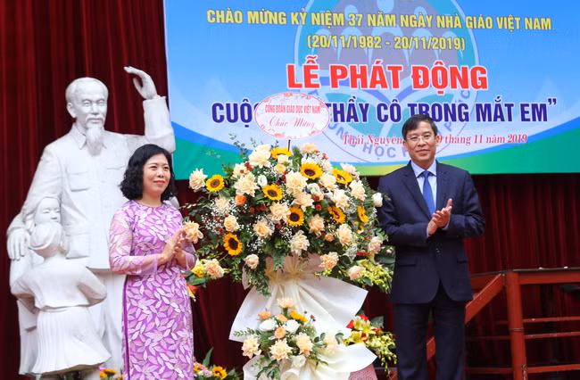 Nhà giáo Lục Thúy Hằng đón nhận lẵng hoa từ TS. Vũ Minh Đức chúc mừng các thầy, cô giáo trong tập thể sư phạmTrường Phổ thông Vùng cao Việt Bắc nhân Ngày Nhà Giáo Việt Nam 20/11. Ảnh: Việt Hà