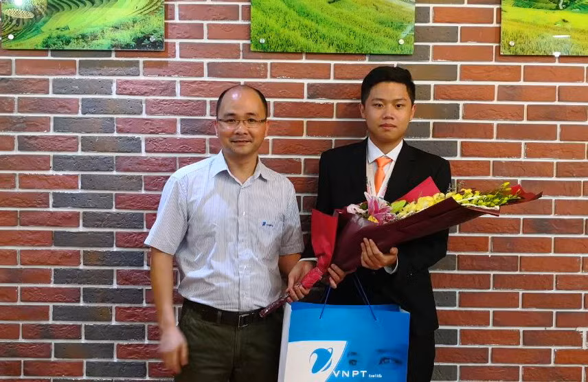 Ông Nguyễn Trọng Nghĩa - Phó Tổng giám đốc VNPT-IT chúc mừng và trao quà cho em Phạm Đức Thắng