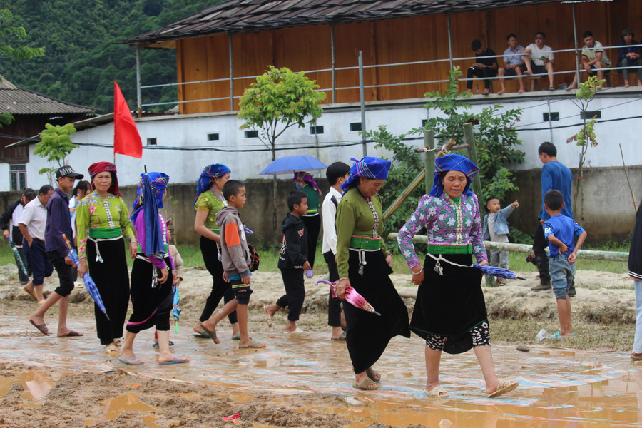 Bà con nhân dân đi trên con đường đất lầy lội tham dự ngày hội.