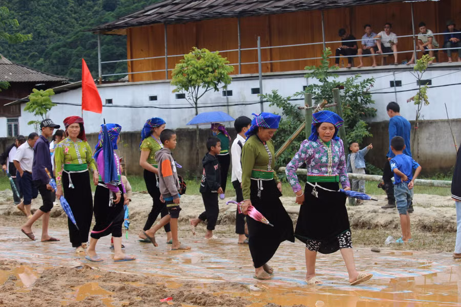 Bà con nhân dân đi trên con đường đất lầy lội tham dự ngày hội.