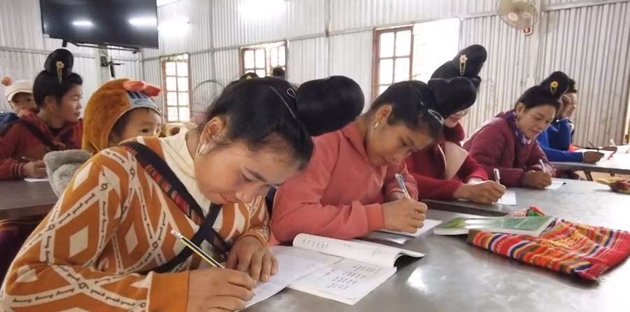 Các học viên đang tập viết chữ tại lớp học.