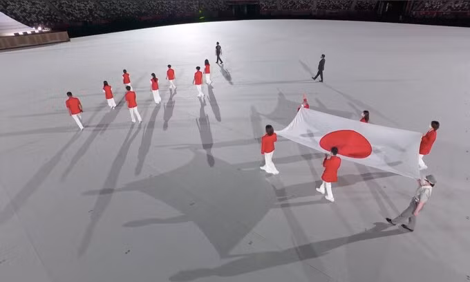 Lá cờ nước chủ nhà Olympic Tokyo 2020, được mang bởi nhiều thế hệ các VĐV Nhật Bản, xuất hiện trong không khí trang nghiêm