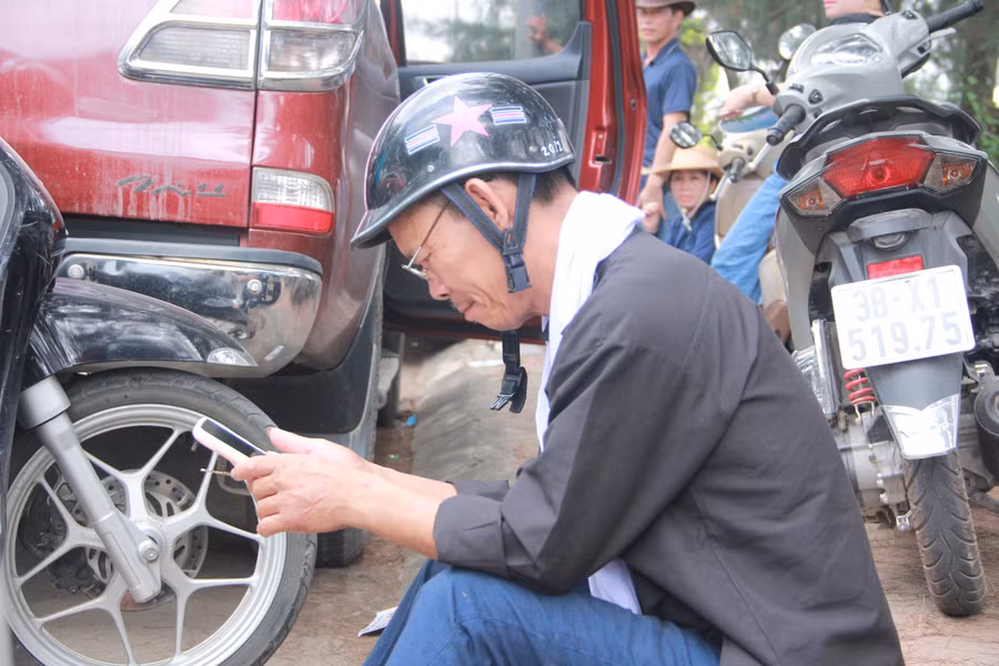 Lâu lâu, người đàn ông đem điện thoại ra xem trong tâm trạng lo lắng, hồi hộp.