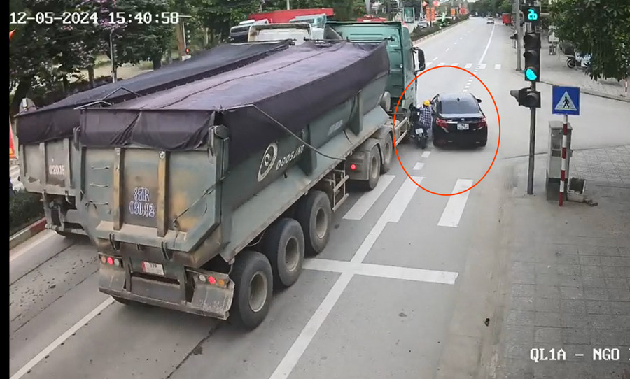 Do vượt ẩu, ô tô đã hất người phụ nữ đi xe máy vào xe tải. (Ảnh cắt từ clip)