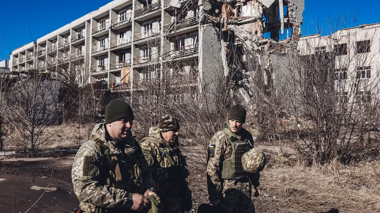 Binh sĩ Ukraine đi qua một tòa nhà bị phá hủy ở Maryinka, tỉnh Donetsk.