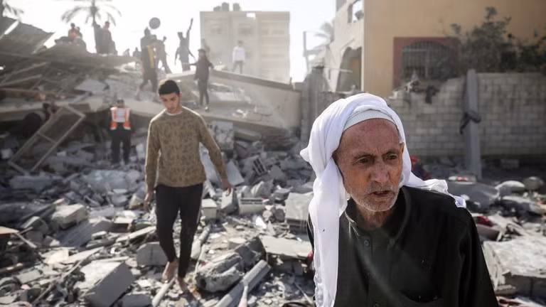 Người Palestine đi qua đống đổ nát của một ngôi nhà bị phá hủy sau vụ đánh bom của Israel hôm 22/12/2023 ở trung tâm Dải Gaza 