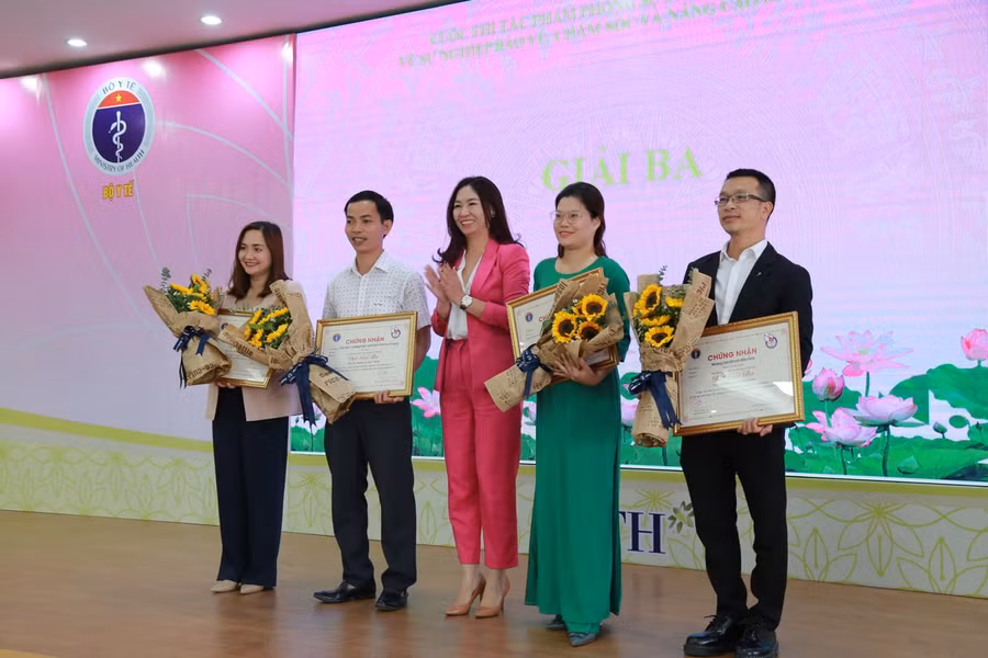 Bà Trần Lan Anh - Phó TBT Báo Nhà báo và Công luận lên trao giấy chứng nhận đạt giải cho các tác giả. Ảnh: Bộ Y tế cung cấp.