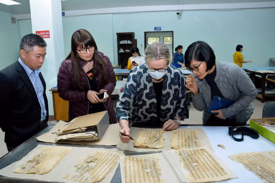 GS Michaelle Biddle thao tác với tài liệu Châu bản tại xưởng tu bổ, Trung tâm Lưu trữ quốc gia I.