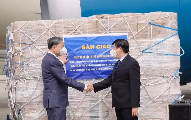 Bộ trưởng Bộ Công an Tô Lâm và Bộ trưởng Bộ Y tế Nguyễn Thanh Long bên lô hàng vật tư, trang thiết bị y tế hỗ trợ điều trị Covid-19. Ảnh: Trần Minh.