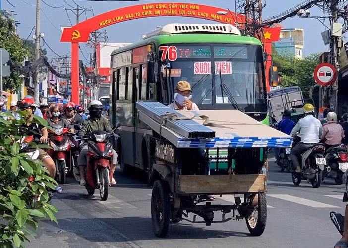 Một xe ba gác thô sơ đang vận chuyển hàng trên đường phố TPHCM.