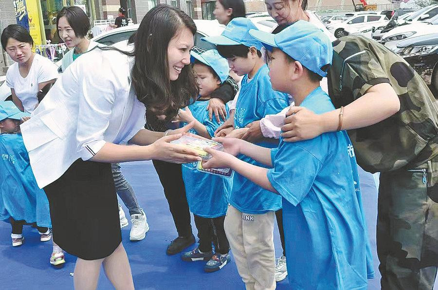 Cô giáo Wang Xinhui, Giám đốc Trung tâm Phục hồi chức năng Star Road, Trung Quốc, trao quà cho trẻ tự kỷ.