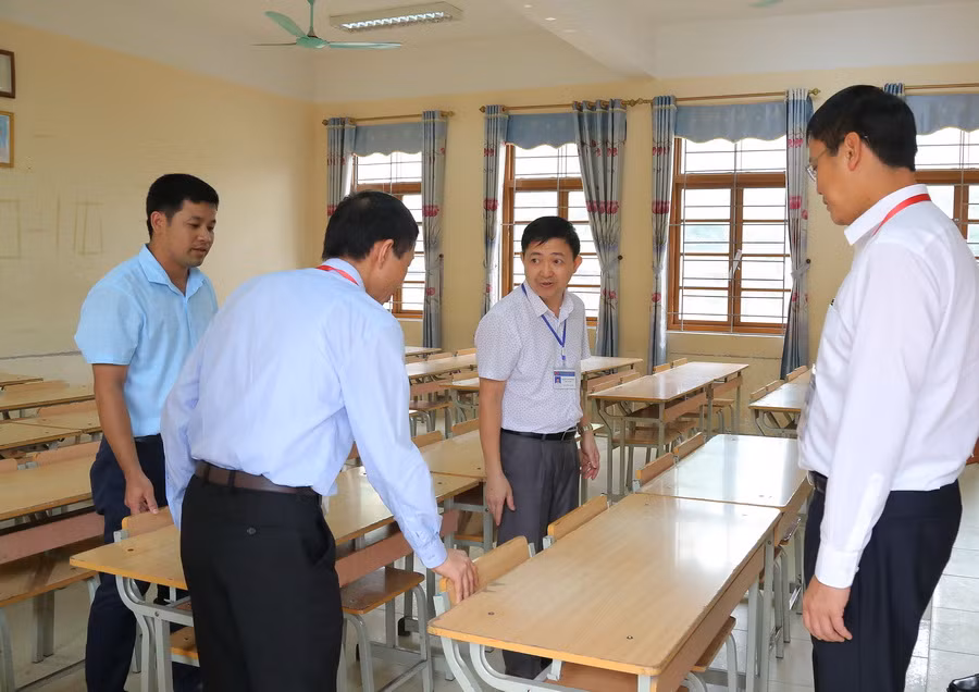 Đoàn kiểm tra đang nhắc nhở các cán bộ tại điểm thi THPT Hữu Lũng phải đảm bảo khoảng cách các thí sinh trong phòng thi. Theo quy chế, phòng thi được xếp theo bài thi, mỗi phòng thi có tối đa 24 thí sinh, trong phòng thi phải đảm bảo khoảng cách tối thiểu giữa 2 thí sinh ngồi cạnh nhau là 1,2 mét theo hàng ngang. Ảnh: Việt Hà
