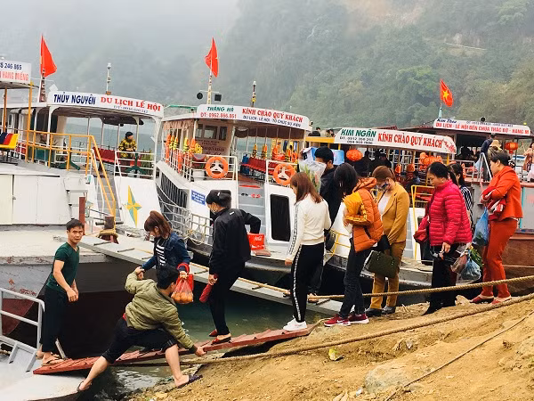 Hành khách đang lên thuyền khách du Xuân lòng hồ thuỷ điện Hoà Bình.