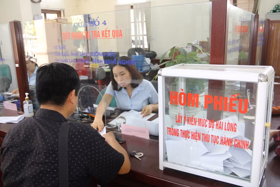 Nhân viên BHXH tỉnh Hoà Bình hướng dẫn người dân làm thủ tục tham gia bảo hiểm.