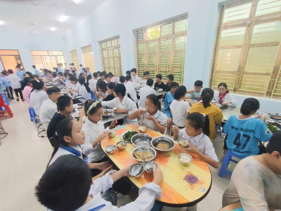 Các em học sinh đang ngồi ăn cơm trưa tại căng tin. Các em học sinh đang ngồi ăn cơm trưa tại căng tin.