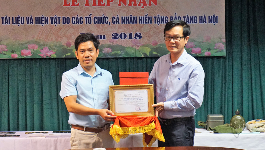 Ông Nguyễn Tiến Đà, Giám đốc Bảo tàng Hà Nội (bên phải) trao Giấy chứng nhận tiếp nhận hiện vật cho BGH Trường THPT Dương Quảng Hàm