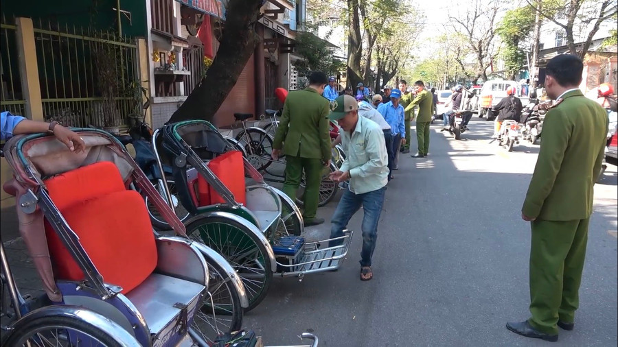 Lực lượng chức năng buộc 134 xích lô "đội lốt" xe điện tháo gỡ bình điện và cam kết không gắn động cơ điện (Ảnh cắt từ video do Công an cung cấp).