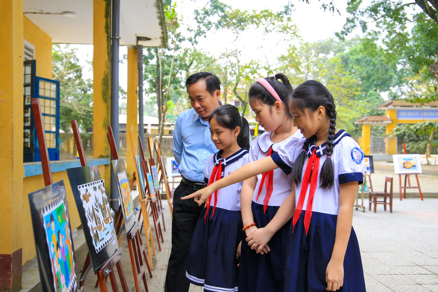 Thầy trò cùng tham quan các sản phẩm Tem bưu chính do các em học sinh sáng tạo với chủ đề “Trả lại màu xanh cho hành tinh của chúng em”.