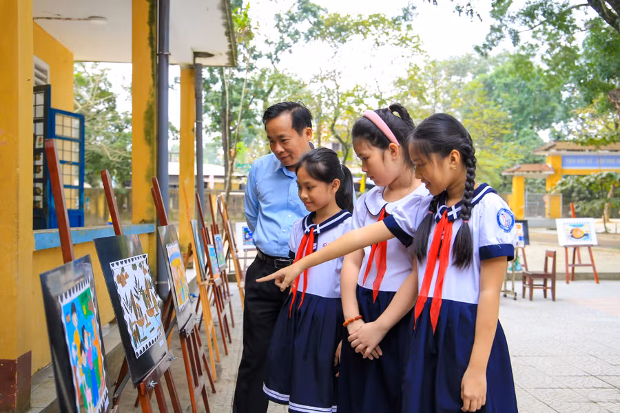 Thầy trò cùng tham quan các sản phẩm Tem bưu chính do các em học sinh sáng tạo với chủ đề “Trả lại màu xanh cho hành tinh của chúng em”.