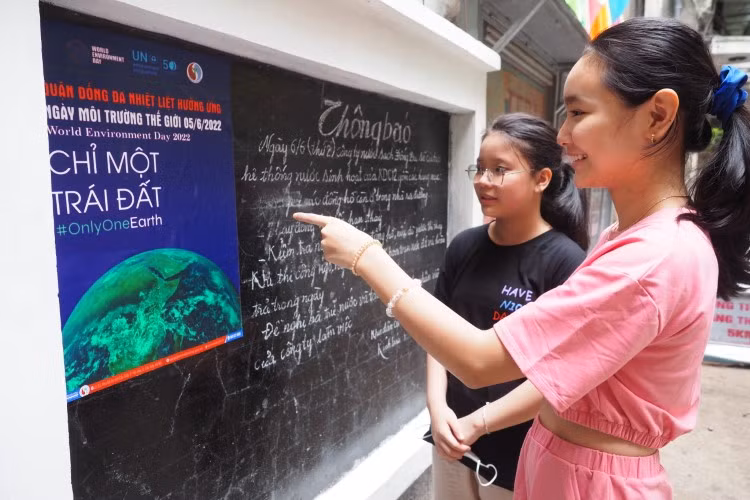 Các em học sinh hào hứng đọc báo tại bảng tin ngách 3/24 phố Thái Hà.