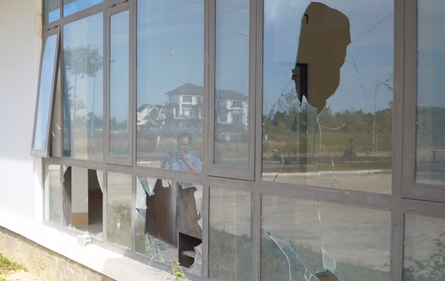 Mặc dù chưa có người ở nhưng một số cửa kính đã bị đập bể. Ảnh: Dung Nguyễn