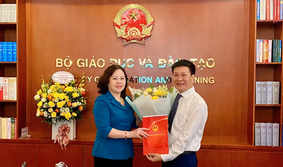 Thứ trường Ngô Thị Minh trao Quyết định bổ nhiệm và tặng hoa chúc mừng Tân Phó Vụ trưởng Vụ Giáo dục Thể chất Nguyễn Nho Huy. Ảnh: An Nhiên