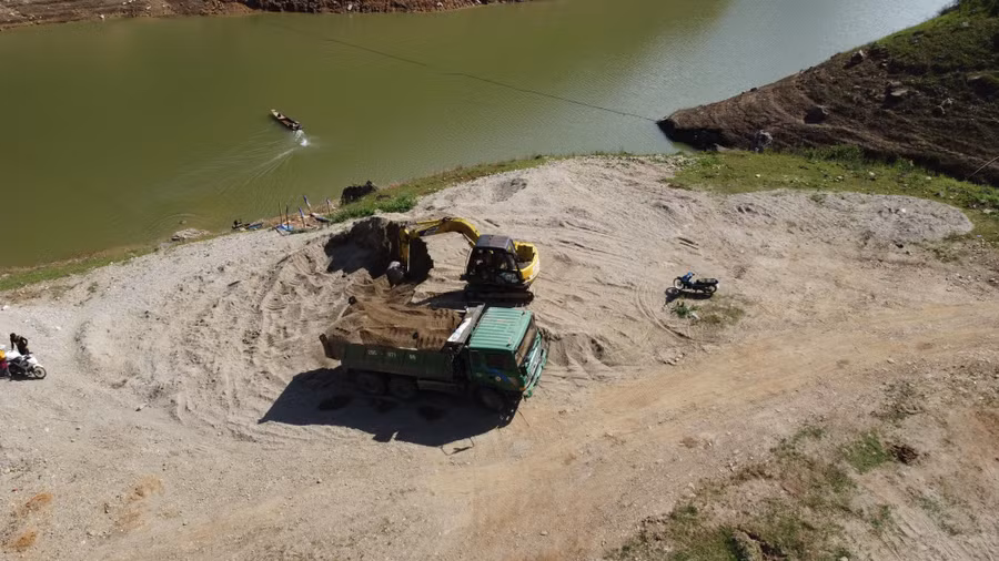 Máy xúc đang múc từng gầu cát chở lên xe tải đi tiêu thụ tại bản Lọng Cang, xã Ngọc Chiến. Ảnh chụp ngày 28/7.