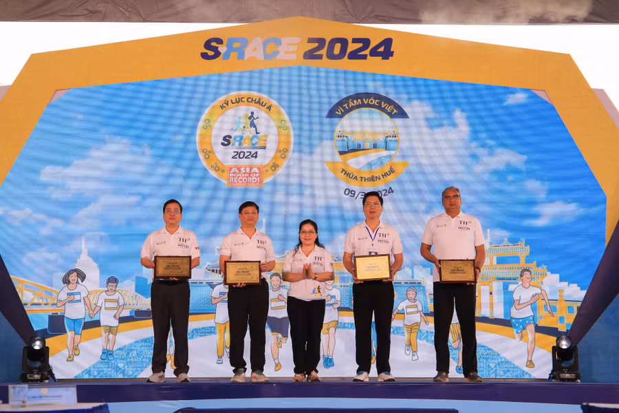 Thứ trưởng Bộ GD&amp;ĐT Nguyễn Thị Kim Chi (giữa) trao bảng vinh danh cảm ơn tỉnh Thừa Thiên Huế và Tập đoàn TH đã đồng hành cùng Giải chạy S-Race 2024.