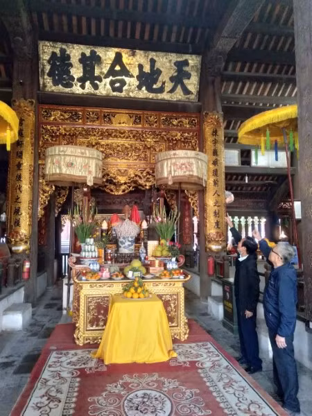 Ông Thuận và ông Đoàn giới thiệu bức Hoành phi có dòng chữ: “Thiên địa hợp kỳ đức” treo ở chính điện Đình Bát Tràng.