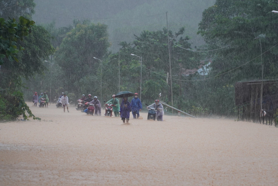Người đi đường liều mình dắt xe qua đoạn nước ngập. Người đi đường liều mình dắt xe qua đoạn nước ngập.