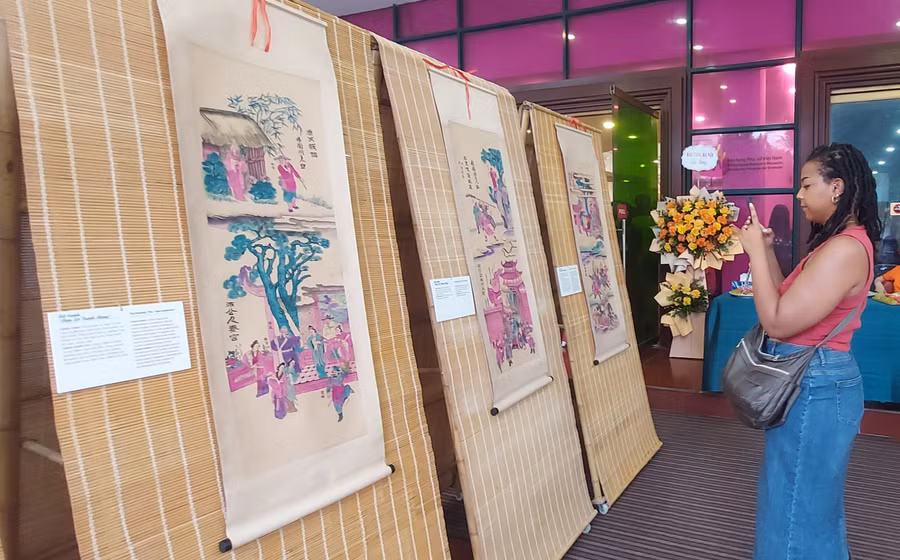 Du khách nước ngoài cũng thích thú chụp hình tranh truyện Hàng Trống. Ảnh: Bình Thanh 