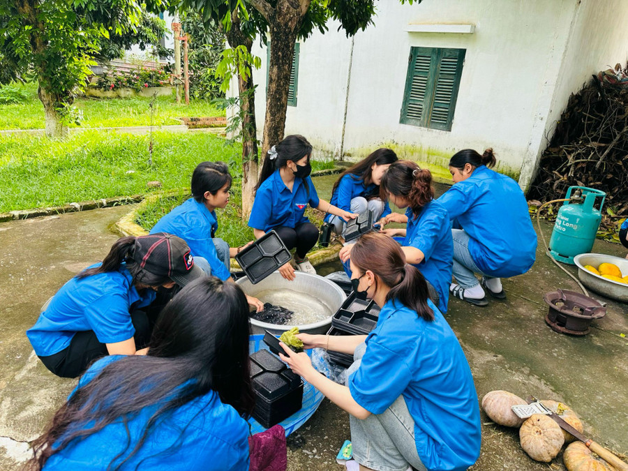 Các tình nguyện viên tập trung rửa khay đựng suất cơm.