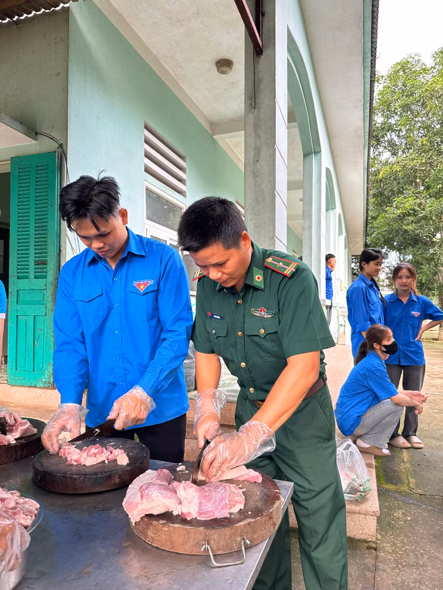 Tình nguyện viên đang thái thịt lợn chế biến món ăn hỗ trợ các học sinh.