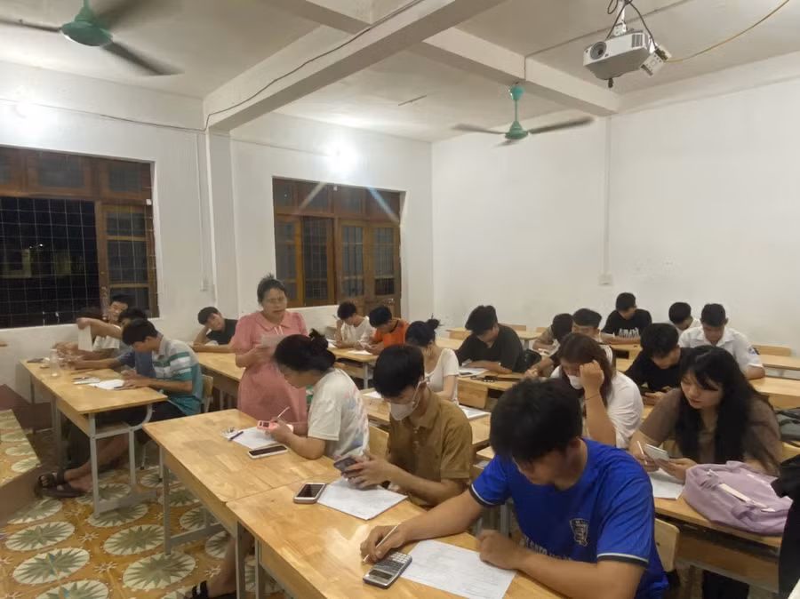 Cô Dân đang dạy phụ đạo kiến thức cho học sinh vào ban đêm.