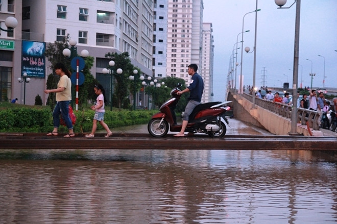 Người dân đi qua cây cầu tạm để về nhà