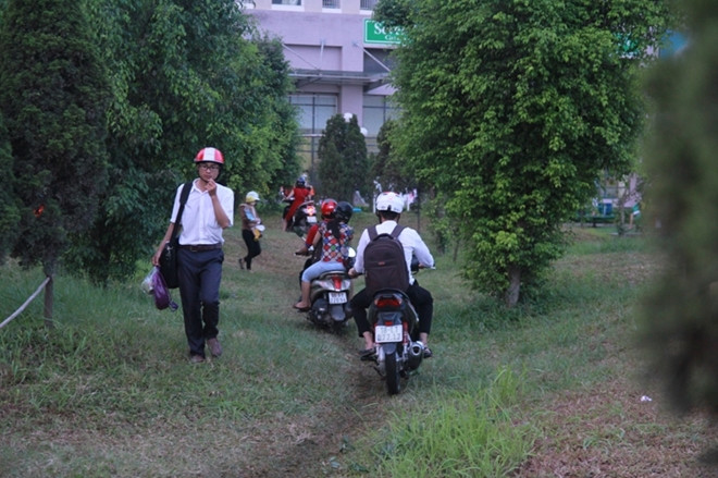 Khi qua cầu tạm, người dân sẽ đi theo đường khuôn viên của chung cư vào nhà xe.