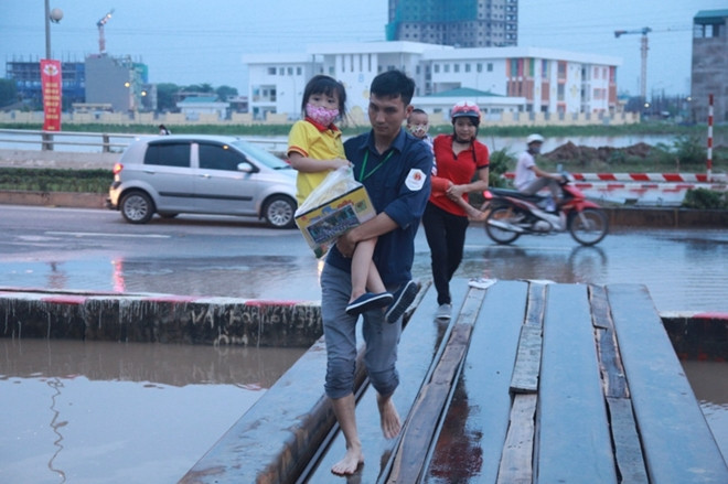 Nhiều cháu nhỏ không phải ngồi xe ba gác qua đoạn bị ngập.