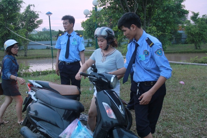 Nhân viên bảo vệ chung cư giúp người dân đi xe máy qua cầu.