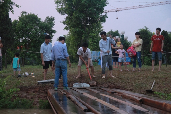 Để phục người dân đi lại thuận tiện, BQL chung cư đã lắp tạm cây cầu sắt băng ngang qua đoạn đường bị ngập
