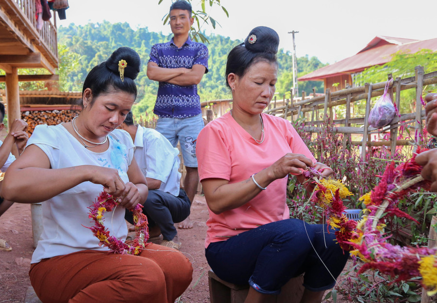 Phụ nữ người Cống ở Lả Chà tết các vòng hoa Mào gà để đội đầu. Phụ nữ người Cống ở Lả Chà tết các vòng hoa Mào gà để đội đầu.
